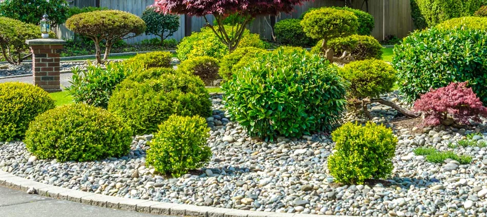 River rock installed in a large circular landscape bed in the courtyard of a home in Washington, PA.